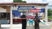 Anggota DPRK Aceh Besar Arfiansyah, S.Pd menyerahkan Masker yang diterima oleh aparatur gampong